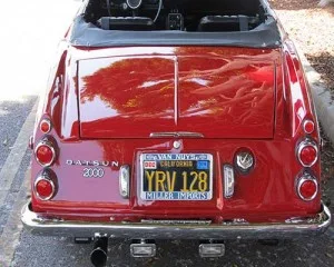 Red 1969 Datsun convertible, rear view with top down